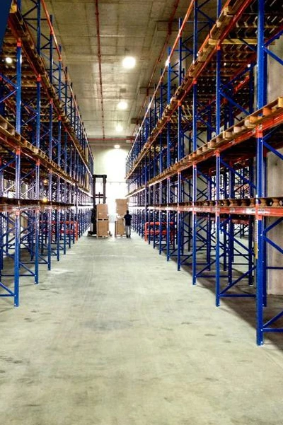 Pasillo de almacén industrial con racks de gran altura, tomado de la carta de presentación